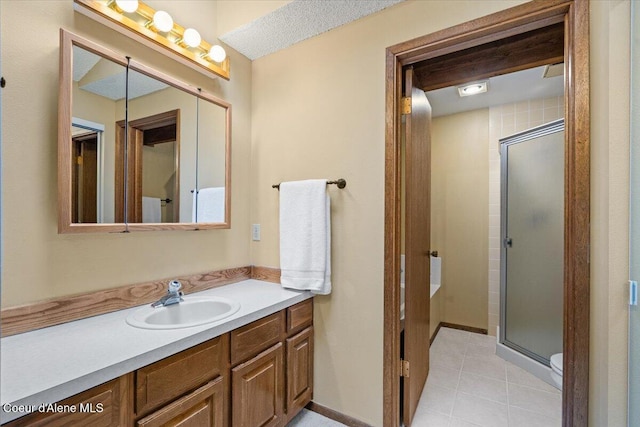 full bathroom with tile patterned flooring, a shower stall, vanity, and baseboards