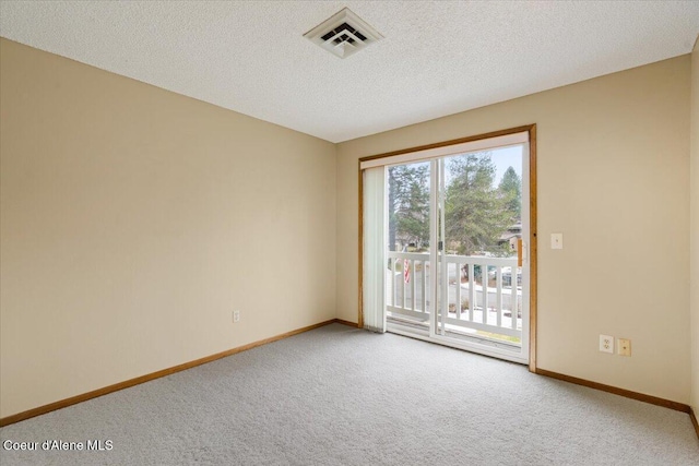 spare room featuring baseboards, visible vents, a textured ceiling, and carpet flooring