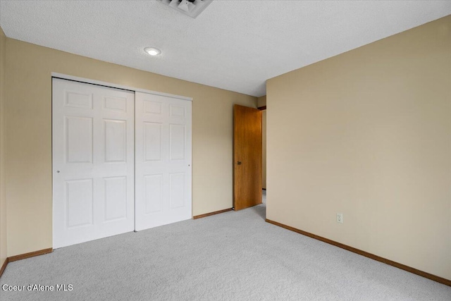 unfurnished bedroom featuring carpet floors, baseboards, visible vents, and a closet