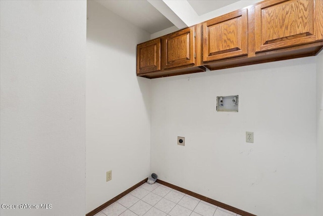 washroom featuring light tile patterned flooring, hookup for an electric dryer, washer hookup, baseboards, and cabinet space