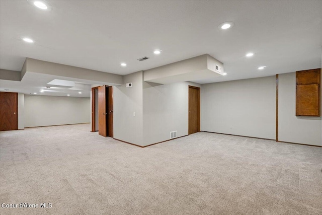 finished below grade area featuring recessed lighting, light carpet, and visible vents