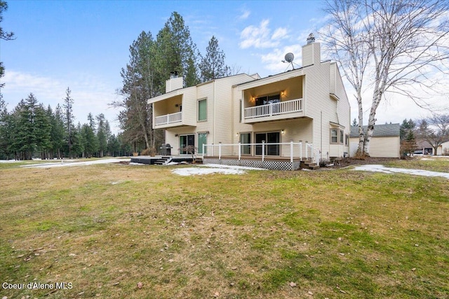 rear view of property with a yard and a chimney