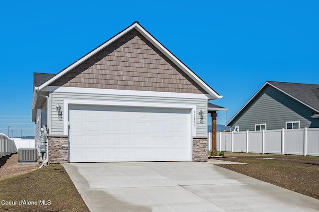 view of front of house with cooling unit, a garage, fence, stone siding, and driveway