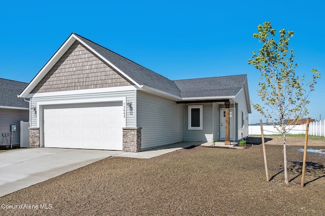 view of front of property featuring a shingled roof, fence, a garage, stone siding, and driveway