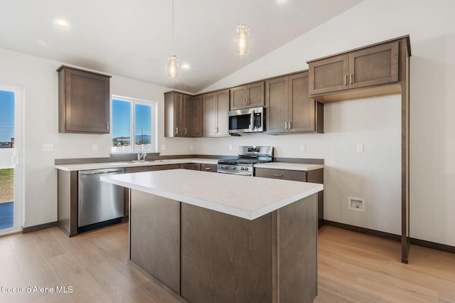 kitchen with dark brown cabinetry, stainless steel appliances, a kitchen island, a sink, and light wood finished floors