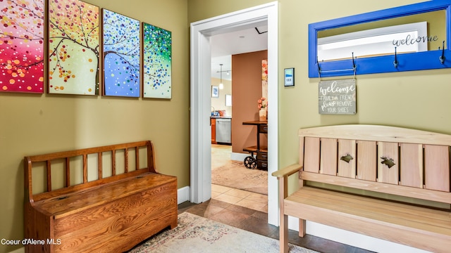 hall featuring tile patterned flooring and baseboards