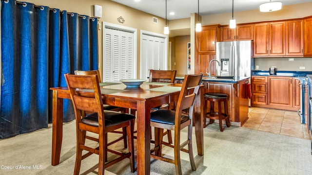 dining room featuring light colored carpet, visible vents, and light tile patterned floors