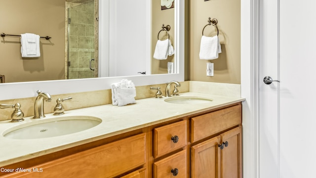 full bathroom with a sink, a shower stall, and double vanity