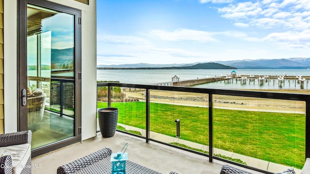 balcony with a sunroom and a water and mountain view