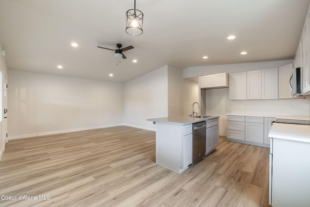 kitchen with light wood-style flooring, a sink, a ceiling fan, open floor plan, and appliances with stainless steel finishes