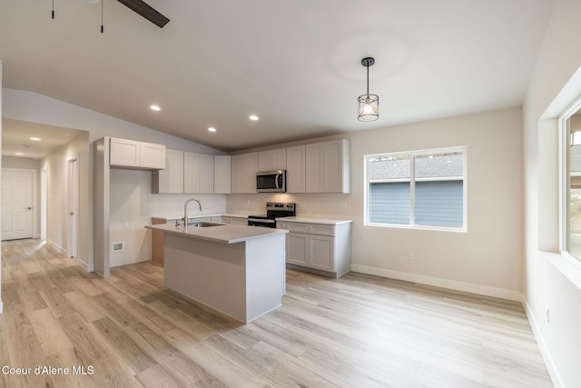 kitchen with vaulted ceiling, stainless steel appliances, light wood-type flooring, and a sink