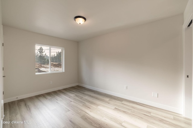 unfurnished room with light wood finished floors and baseboards