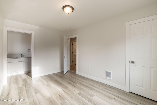 unfurnished bedroom with visible vents, light wood finished floors, and baseboards