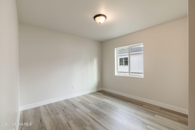 empty room with light wood-type flooring and baseboards