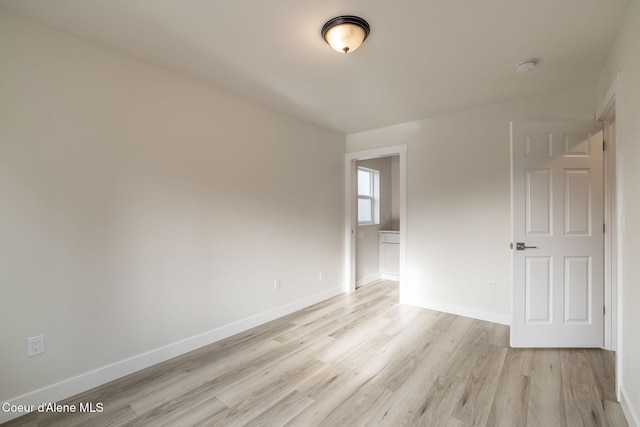 spare room featuring light wood finished floors and baseboards