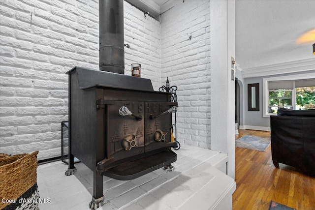 room details featuring baseboards, wood finished floors, a wood stove, and crown molding