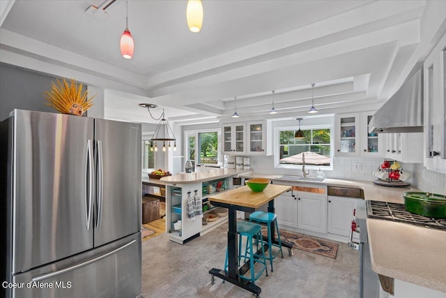 kitchen featuring appliances with stainless steel finishes, glass insert cabinets, white cabinets, and tasteful backsplash