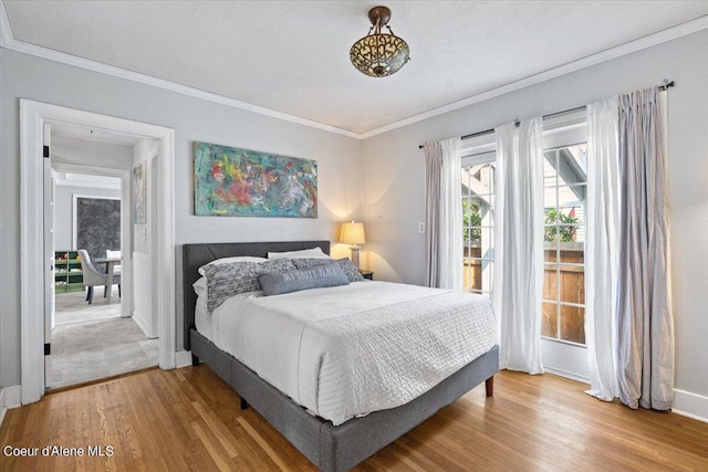 bedroom with ornamental molding, access to outside, baseboards, and wood finished floors