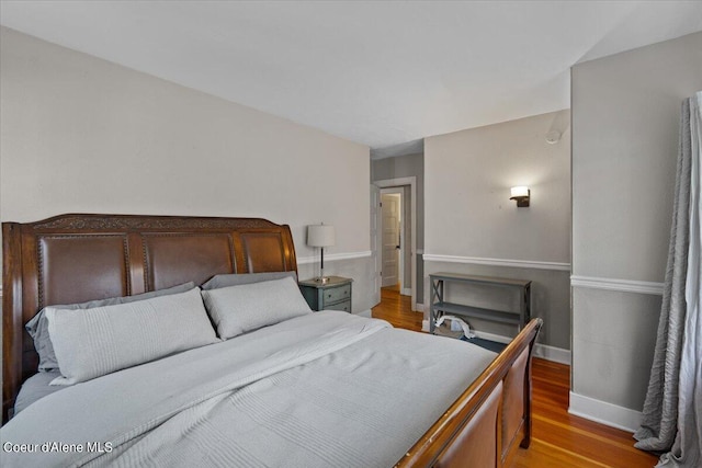 bedroom with baseboards and wood finished floors