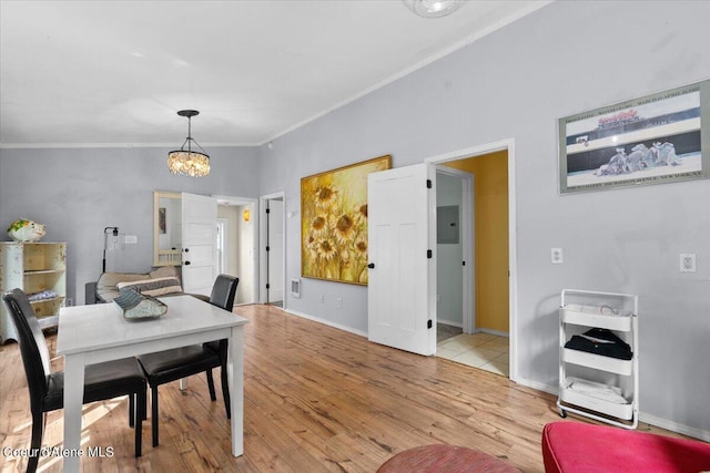 dining space with baseboards, crown molding, a chandelier, and wood finished floors