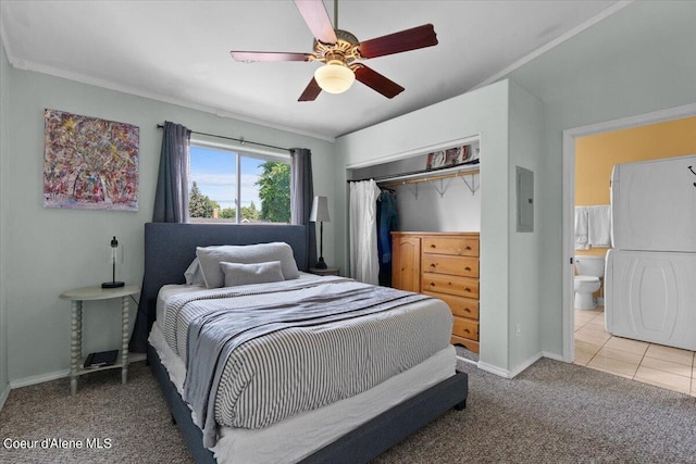 carpeted bedroom with a closet, ceiling fan, stacked washing maching and dryer, electric panel, and baseboards