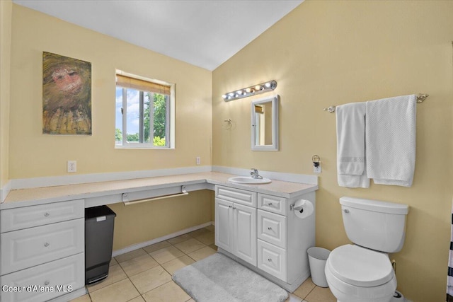 bathroom with vaulted ceiling, vanity, toilet, and tile patterned floors