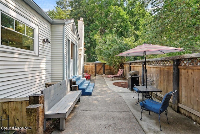 view of patio / terrace featuring entry steps, a fenced backyard, and a grill