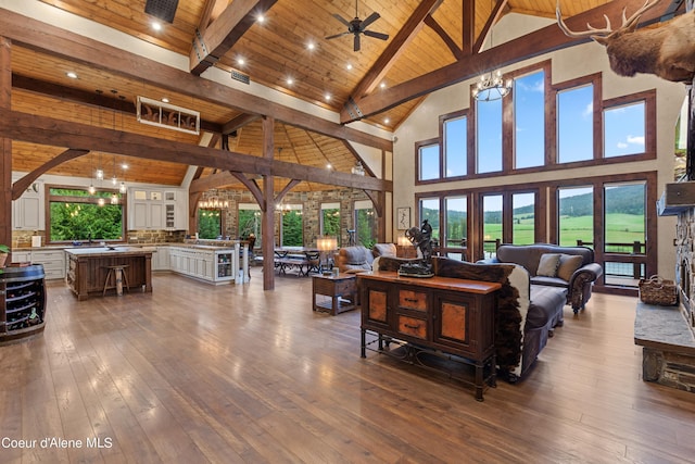 living area featuring a wealth of natural light, wooden ceiling, beamed ceiling, and dark wood-style flooring