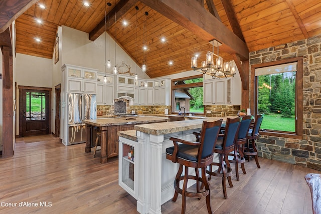 kitchen with decorative backsplash, wooden ceiling, high quality fridge, hardwood / wood-style floors, and beam ceiling