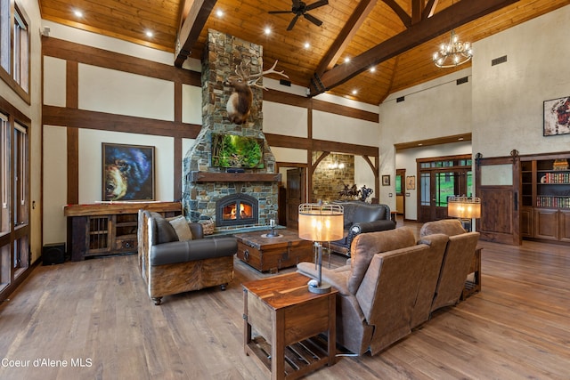 living room featuring wooden ceiling, beamed ceiling, a stone fireplace, and hardwood / wood-style flooring