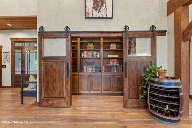 room details featuring wood finished floors, a textured wall, and a barn door