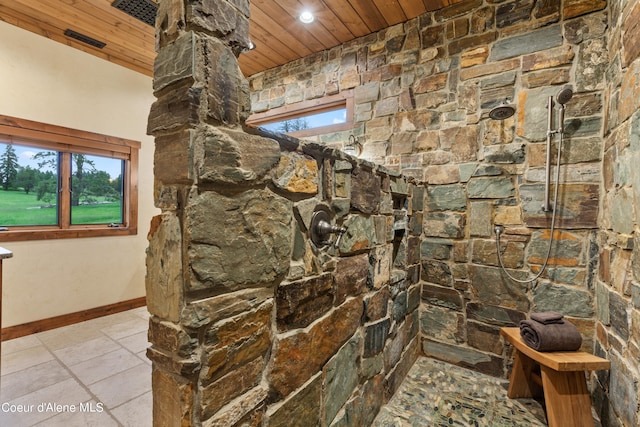 full bath with stone tile flooring, wood ceiling, tiled shower, and baseboards