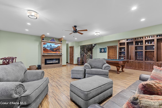 living area featuring a glass covered fireplace, billiards, recessed lighting, and wood finished floors