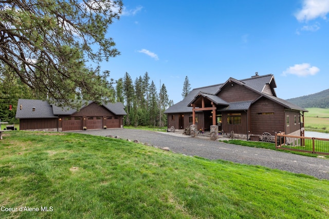 view of front of property with gravel driveway and a front lawn