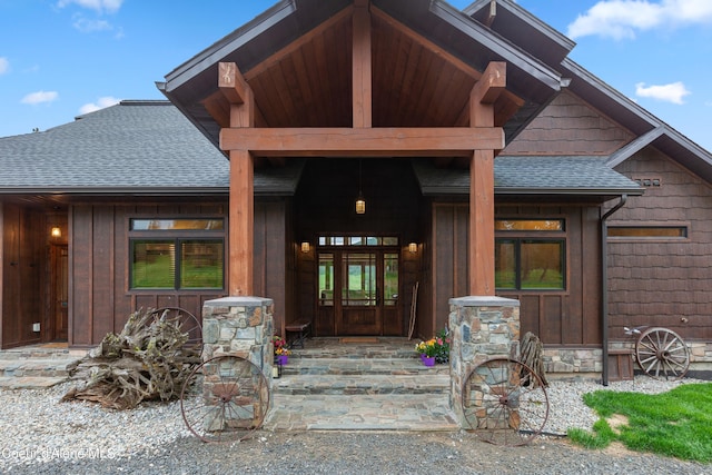 property entrance with a shingled roof, a porch, and board and batten siding