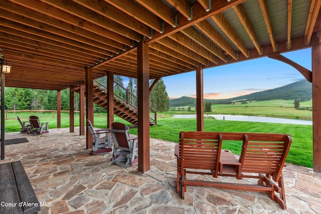 view of patio featuring stairs and a water view