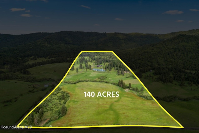 337 Coon Creek Rd, Plummer, ID 83851 - aerial view of property and surrounding area with a forest, property parcel outlined, and mountains