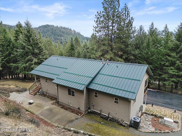 exterior space featuring a standing seam roof, metal roof, and a forest view