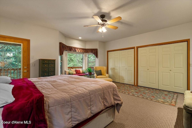 bedroom with access to exterior, carpet, a ceiling fan, and two closets