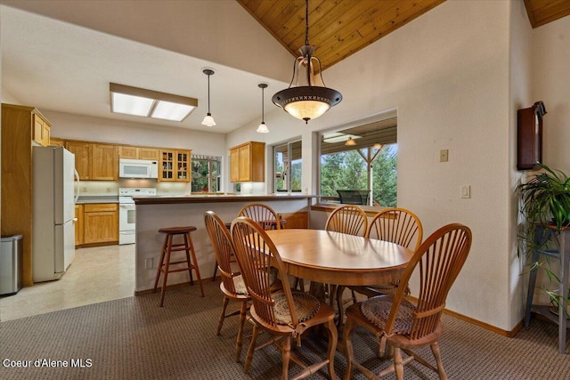 dining room with high vaulted ceiling, wood ceiling, and baseboards