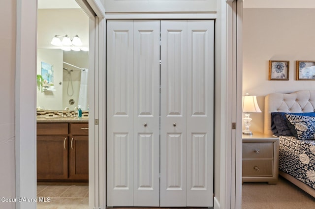 bathroom featuring vanity, tile patterned floors, a closet, and connected bathroom