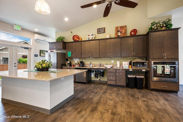 kitchen with a wall unit AC, high vaulted ceiling, stainless steel appliances, dark brown cabinetry, and a center island