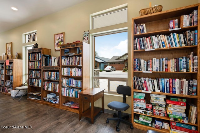 office area with bookshelves, wood finished floors, and baseboards