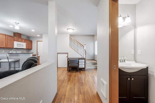 interior space featuring stairway, light wood-style floors, visible vents, and a sink