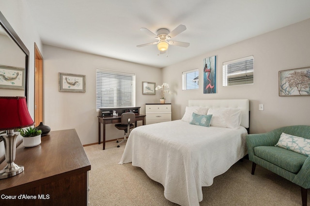 bedroom featuring a ceiling fan, multiple windows, light colored carpet, and baseboards