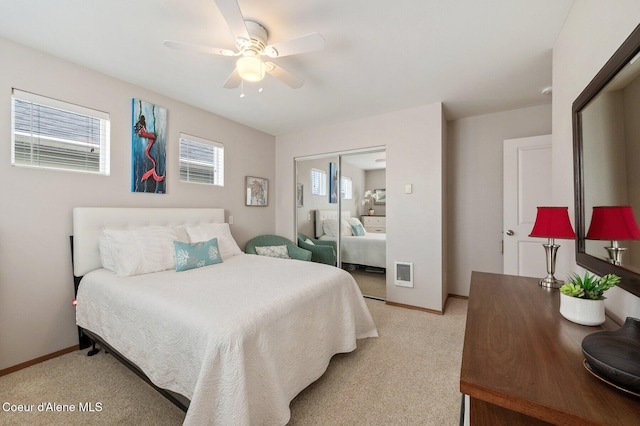 bedroom with a ceiling fan, baseboards, a closet, and light carpet