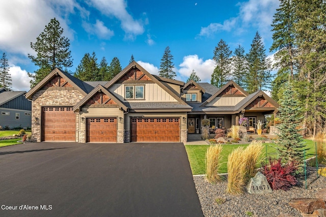 craftsman house featuring stone siding, aphalt driveway, and board and batten siding