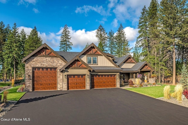 craftsman-style house with stone siding, aphalt driveway, board and batten siding, and a front yard