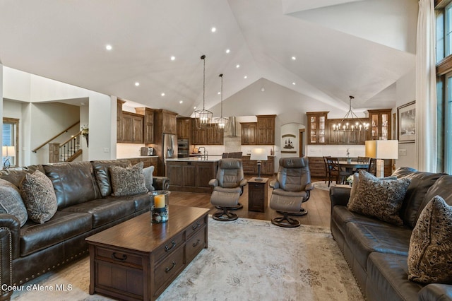 living area with a chandelier, light wood-style flooring, stairway, high vaulted ceiling, and recessed lighting