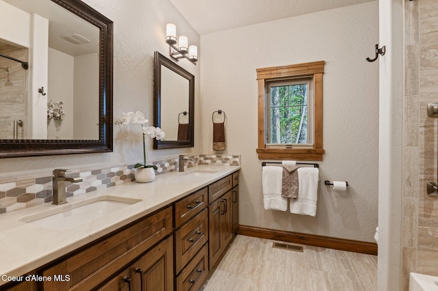 full bathroom featuring double vanity, baseboards, backsplash, and a sink